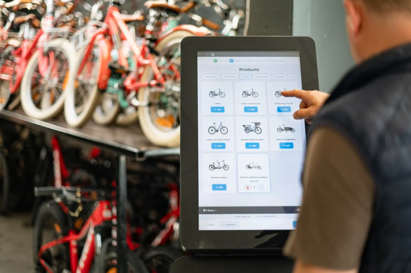 Klant kiest een fiets op het touchscreen van de verhuurkiosk